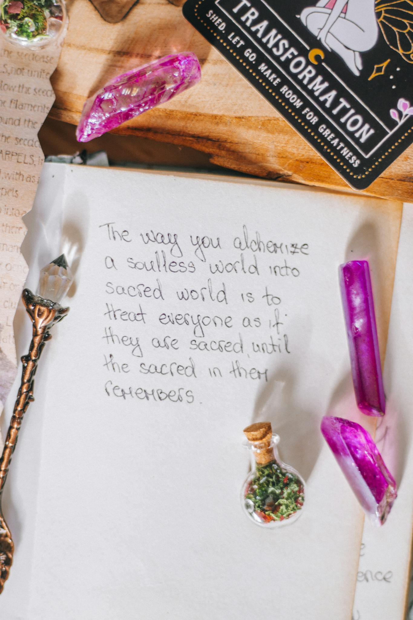 A top view of a journal page featuring esoteric handwriting, crystals, and alchemy elements.